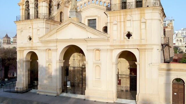 Exterior view of the Cathedral of Cordoba, Argentina. Drone rising in front of facade and revealing cityscape