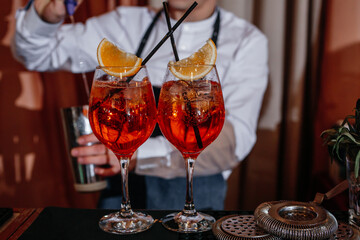Bartender makes red cocktails in a restaurant