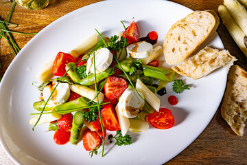 Asparagus salad with strawberries, tomatoes and goat cheese