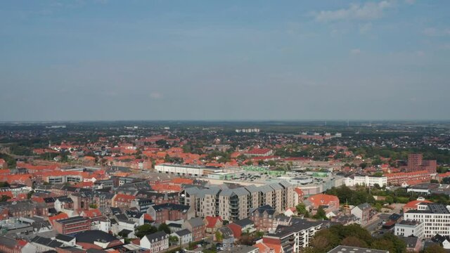 Aerial panning view of the city of Esbjerg, Denmark. Drone view flight towards over neighborhoods and the brick roof of one of the most important seaport of North sea