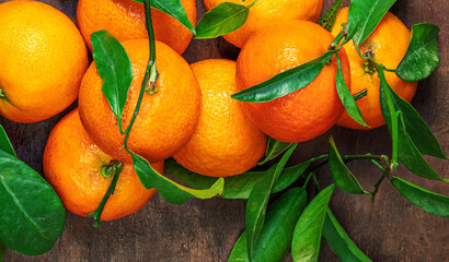 Mandarines oranges fruits or tangerines with green leaves on a wooden table. Copyspace. Fresh picked mandarins T