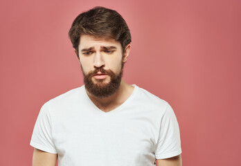 Obraz premium bearded man in a white t-shirt irritated facial expression close-up