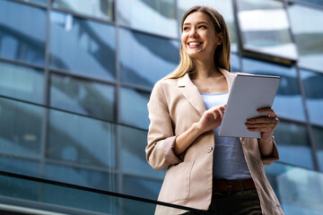 Portrait of successful woman using digital tablet in urban background. Business people concept