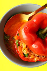 Stuffed pepper in bowl on yellow background