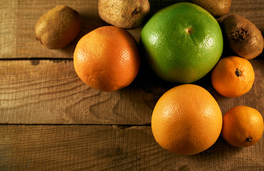 Multiple citrus fruits on a wooden background
