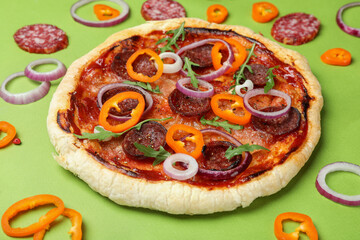 Concept of tasty food with Salami pizza on green background