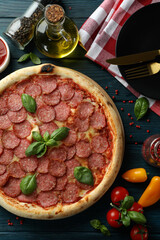 Concept of tasty food with Salami pizza on wooden table