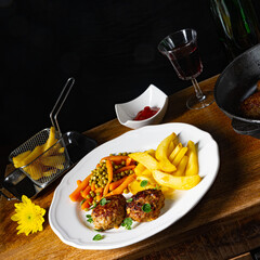 Homemade meatballs with french fries and vegetables