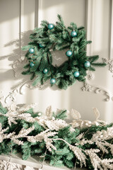 Decorations for the new year, a wreath of fir branches on the wall. Christmas decorative wreath in a cozy home