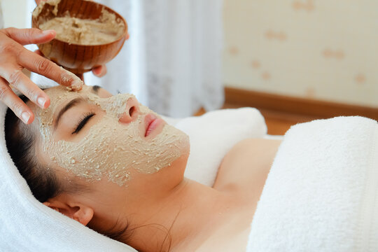 Asia Woman Having Face Treatment In Spa Salon On The Bed, Beauty Natural Facial Mask