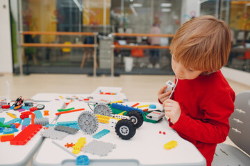 Little boy kid child constructor checking technical toy. Children Robotics constructor assemble robot