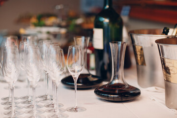 the waiter pours elite red wine into the decanter on the table in the restaurant.