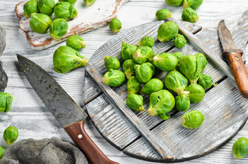 Vegetables. Fresh green brussels sprouts on a white wooden background. Rustic style. Top view.