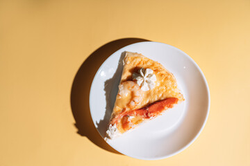 Slice of pizza with seafood on white plate.