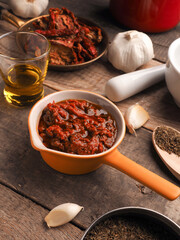 Tasty tomato pesto on a wrustic wooden table