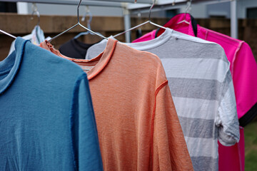 Old T-shirt in different color hanging on clothes line.
