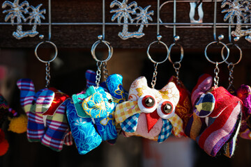 Smiling doll face of keychain hung on metal hook.