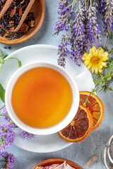 Tea. Herbs, flowers, and fruit, shot from the top with a cup of tea, a flat lay with dry orange and lavender