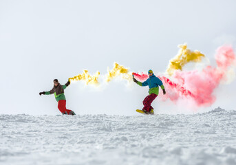 Two snowboarders with smoke torch at ski slope