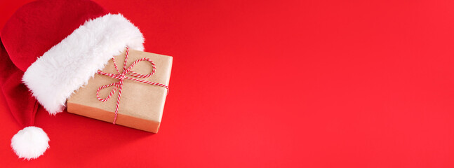 banner gift box in a hat santa claus on a red background top view with place for text 
