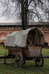 Fototapeta na wymiar old carriage at the walls of the old castle in the park