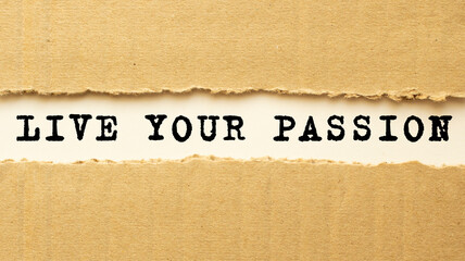 Text LIVE YOUR PASSION appearing behind torn brown paper. Top view.