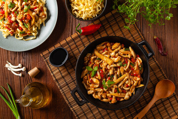Traditional noodles with shimeji mushrooms and chicken. Prepared in a wok.