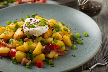 Traditional American hash with fried eggs. Front view.