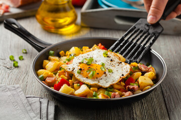Traditional American hash with fried eggs. Front view.