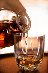 Human hand - Whiskey glass close up in a dark bar setting. Selective focus on the glass. Copy space.High quality photo