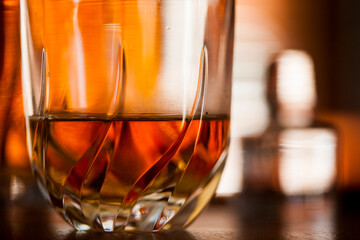 Whiskey glass close up in a dark bar setting. Selective focus on the glass. Copy space.High quality photo