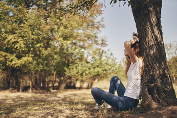 woman sitting near a tree nature Lifestyle summer