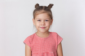 Portrait of caucasian calm little girl of five years old on the white background looking at camera
