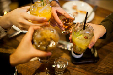 Group of people cheering with caipirinha drink glasses - Happy young friends enjoying lunch in a bar with food e drink -- Youth concept - High quality photo
