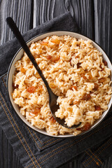 Authentic Colombian Arroz Con Coco Coconut Rice is a classic dish native to the Carribean coastal regions of Colombia close up in the bowl on the table. Vertical top view from above