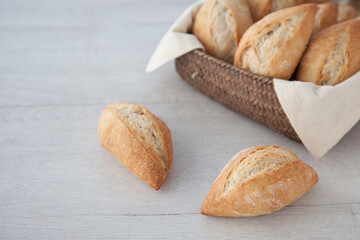 Little roll breads in basket on wooden background