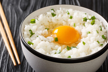 Tamago kake gohan rice topped with egg it is a simple but incredibly popular dish in Japanese cuisine closeup in the bowl on the table. Horizontal