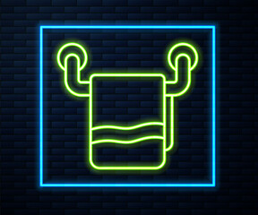 Glowing neon line Towel on a hanger icon isolated on brick wall background. Bathroom towel icon. Vector