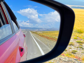 Mountain landscape reflected in the rearview mirror