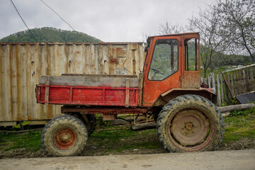 Old red tractor in the village