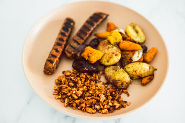 vegan sweet potato black beans sausages with bbq tofu and roasted potatoes and carrots, healthy plant-based food
