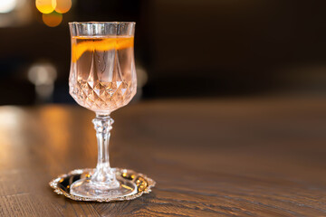 Party cocktail in a crystal glass, on the table. Sparks and bokeh. Copy space. Banner
