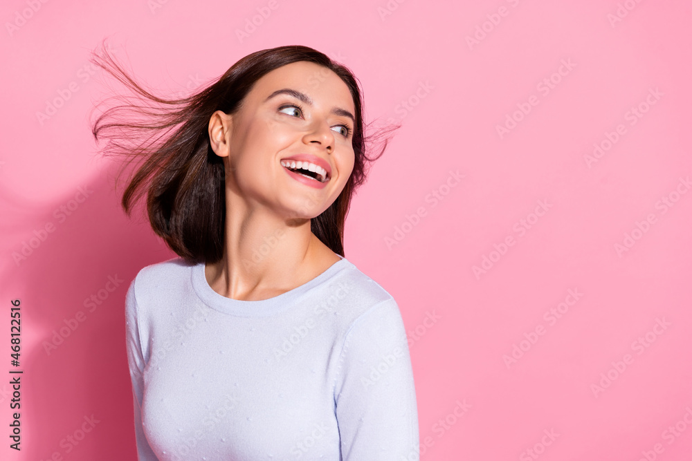 Poster Photo of funky dreamy young lady dressed white jumper wind blowing looking empty space isolated pink color background