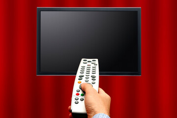 hand holding a remote control and blank tv screen, home theatre concept