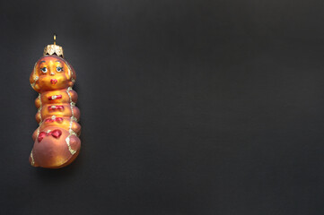 happy new year and christmas. greeting card. on a dark background toy in the form of a caterpillar. rarity