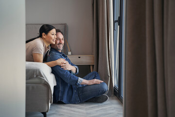 Obraz premium Jolly mature couple communicating in bedroom