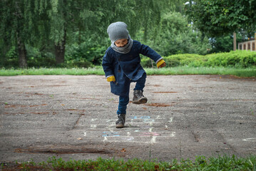 Fototapeta premium games on the playground, games on the street, a child jumps on the asphalt, plays hopscotch,chalk drawing on the asphalt