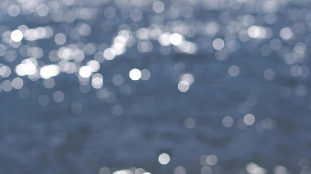 Beautiful blue sparkling sunny defocused river or sea water. Abstract 4k bokeh video background