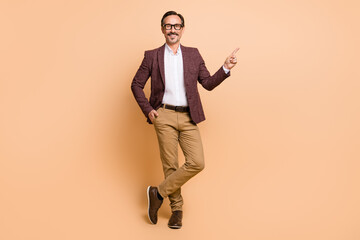 Fototapeta na wymiar Full length body size view of attractive cheery man demonstrating copy space advert offer isolated over beige color background