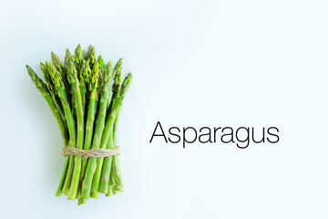 Asparagus in a bunch on a white background.Asparagus for sale in a store.Young juicy asparagus for cooking.Proper nutrition with asparagus.Vegan healthy food.Asparagus ingredient isolated on white bac